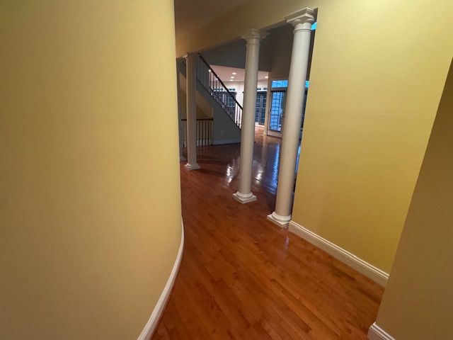 Narrow upstairs hall with a newly refinished hardwood floor wrapping around a stair opening.