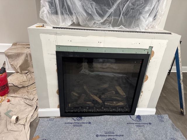 Fireplace insert with a new white surround protected for finishing and paint.
